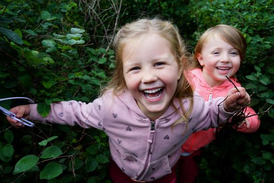 To jenter leker gjemsel i gr&oslash;nne busker