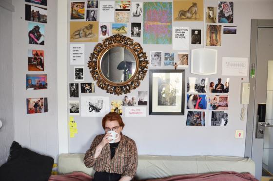 June Kittelsen sitter i senga p&aring; hybelen sin med en kaffekopp