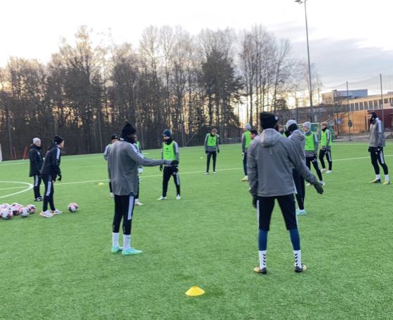 Fotballspillere st&aring;r innenfor kjegler