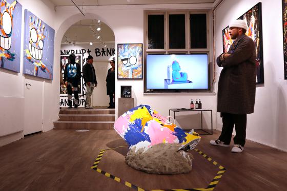 En fyr st&aring;r og beundrer maleriene til King Bankrupt 