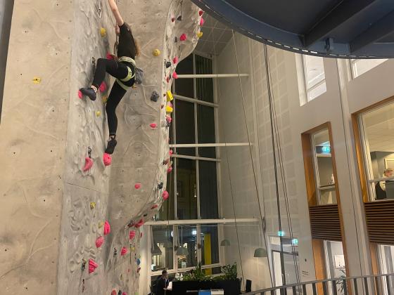 Jente p&aring; vei opp klatreveggen. 