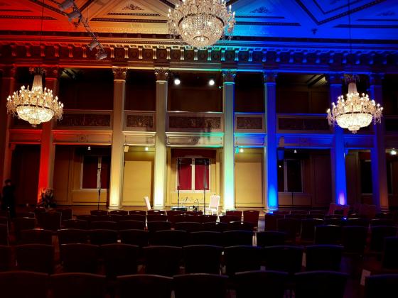 Konsertsal belyst av regnbuens farger.