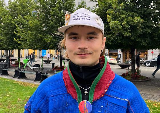 Bilde av Mihkkal H&aelig;tta, en mann i samekofte utenfor Stortinget i Oslo. 