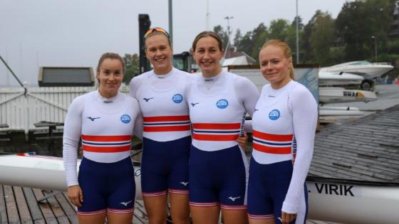 De fire padlerne er if&oslash;rt norgesdrakter og smiler ved siden av hverandre