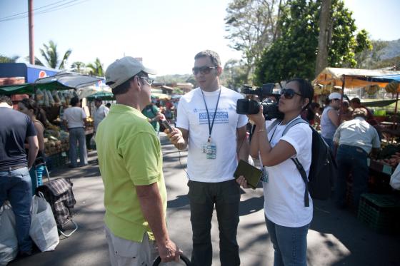 To journalister intervjuer en mann p&aring; et travelt marked i Costa Rica. 