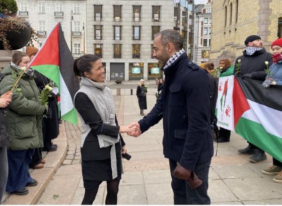Aksjonist Rami Samandar h&aring;ndhilser med politiker Lan Marie Berg utenfor Stortinget
