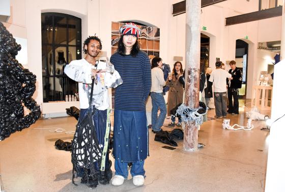 to folk som st&aring;r foran en utstilling