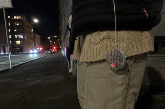 Refleks som henger ut av en lomme i en m&oslash;rk gate.