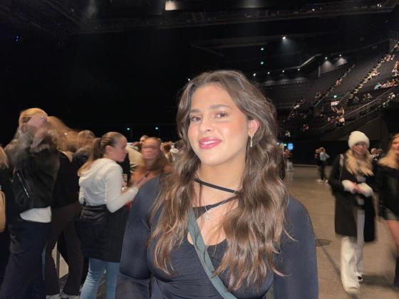 Jente m&oslash;rkt h&aring;r, svart genser, st&aring;plass p&aring; konsert