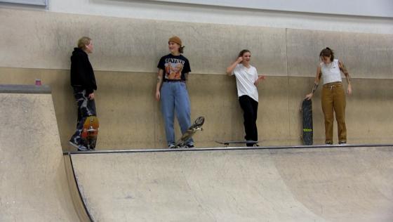 Marte Gundersen og Tiril Melby st&aring;r sammen med andre jenteskatere i Oslo Skatehall
