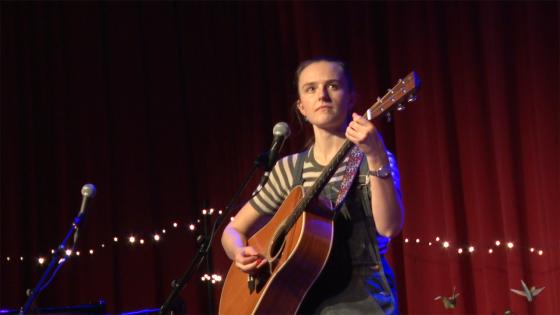 Kvinne som spiller gitar p&aring; scenen