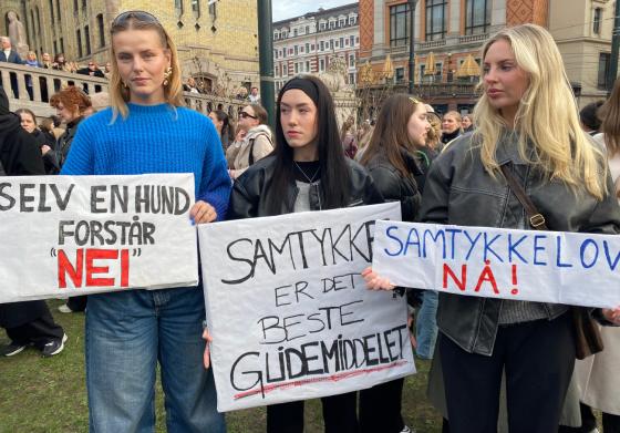Tre jenter holder skilt p&aring; demonstrasjon for samtykkelov.