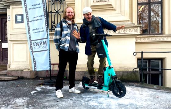 To gutter som st&aring;r p&aring; en el-sparkesykkel