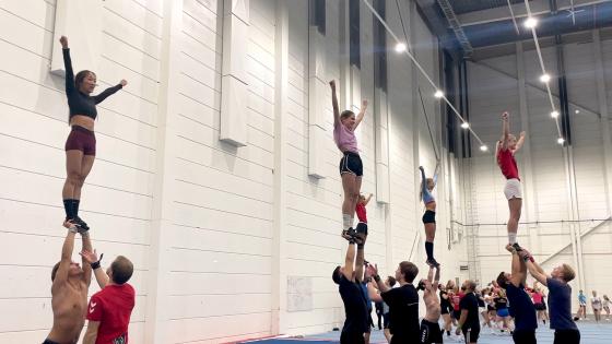 Jenter blir l&oslash;ftet opp i et cheerleaderstunt