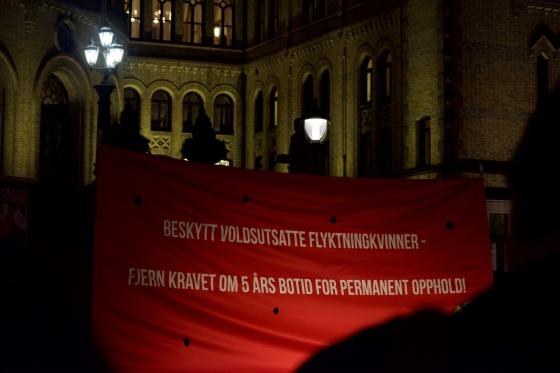 R&oslash;d banner p&aring; plassen foran Stortinget der det st&aring;r beskytt voldsutsatte flyktningkvinner fjern kravet om fem &aring;rs botid for permanent opphold
