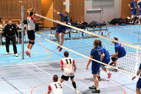En spiller fra BK Troms&oslash; smasher en volleyball forbi en spiller fra OSI som pr&oslash;ver &aring; blokke.