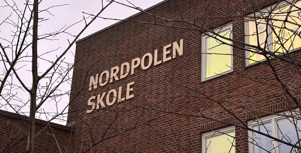 Bide av Nordpolen skole med litt tre uten blader p&aring; siden. Vi ser godt nordpolen skole skiltet