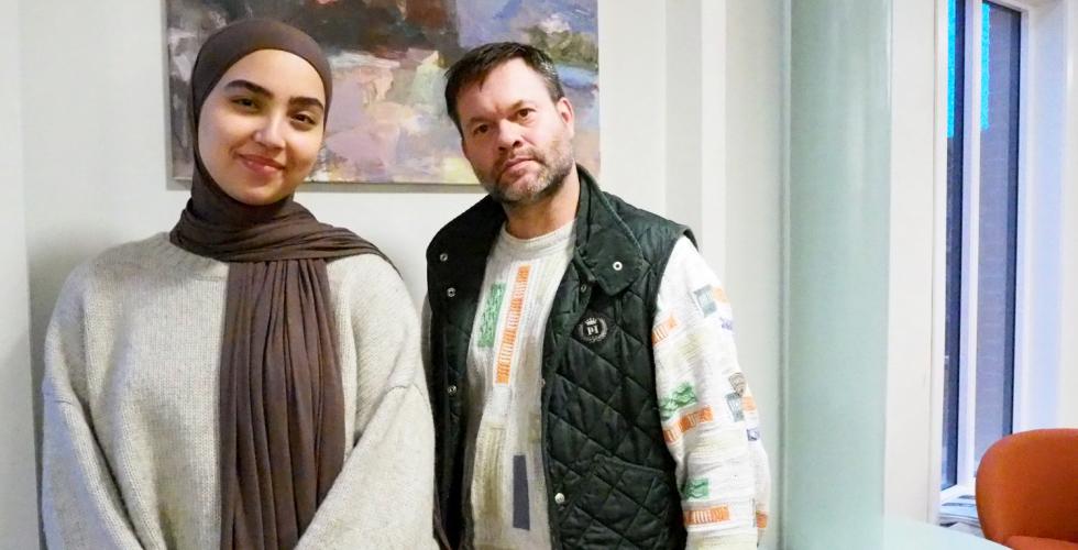 En man og en kvinne st&aring;r ved siden av hverandre. De er avbildet foran et maleri.