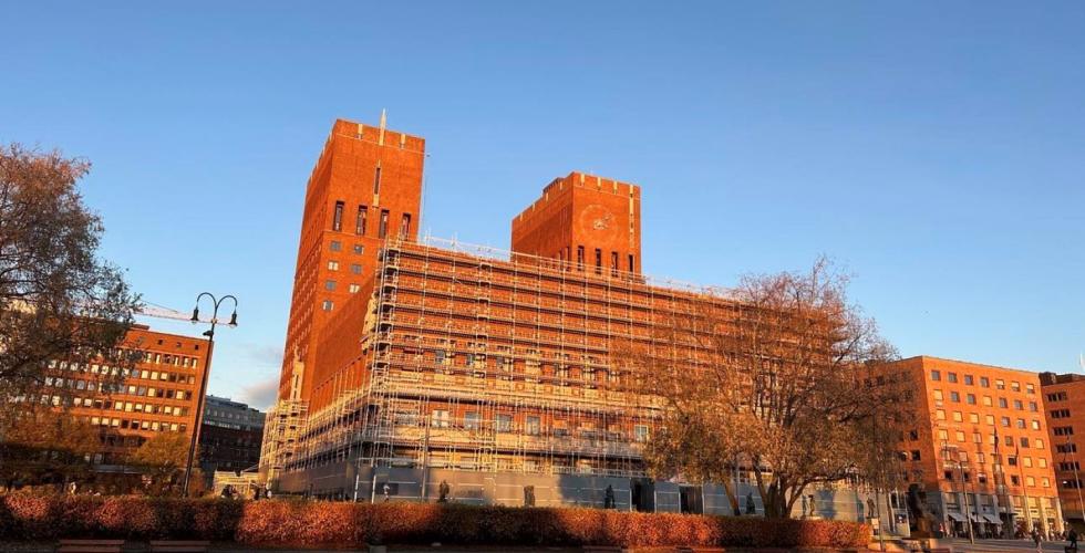 Oslo r&aring;dhus. Et stort murbygg med bl&aring; himmel i bakgrunn.