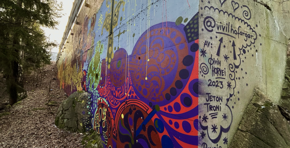 P&aring; hj&oslash;rnet av veggen har kunsterne signert kunstverket.