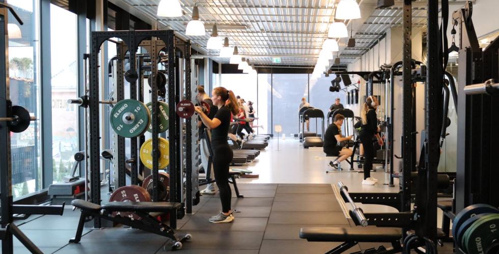 Gangen i et treningssenter. Ulike treningsapperater p&aring; hver sin side. 