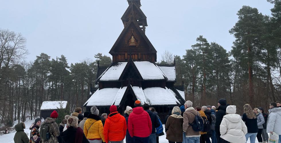 En stavkirke med en mengde mennesker rundt. De er p&aring; omvisning.