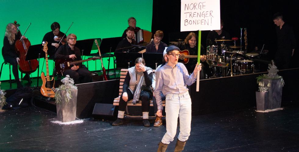 Skuespiller holder et skilt hvor det st&aring;r "norge trenger bonden" 