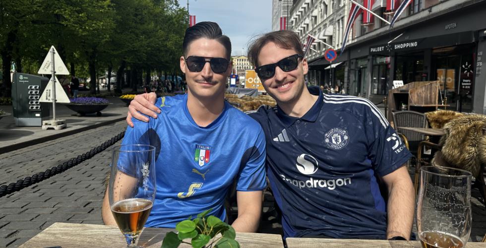 To gutter med fotballdrakt smiler til kamera