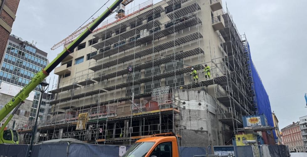 Byggningsarbeidere står på et stilas i Oslo