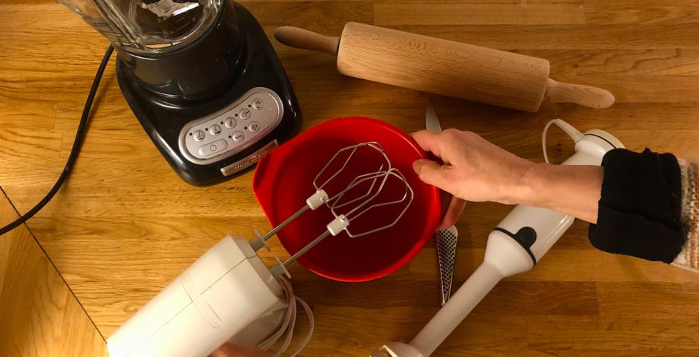 Bilde av en kj&oslash;kkenbolle, stavmikser, kniv, blender. Dame holder h&aring;nden p&aring; bollen