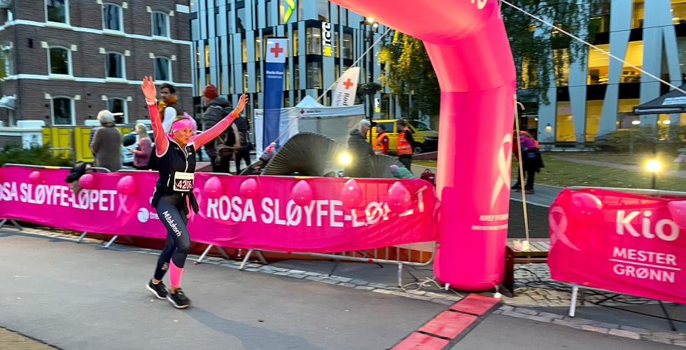 kvinne krysser m&aring;llinjen p&aring; rosa sl&oslash;yfe-l&oslash;p