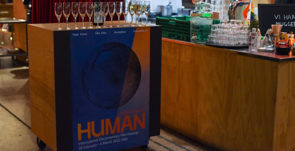 Bilde av glass p&aring; bord med plakat Human