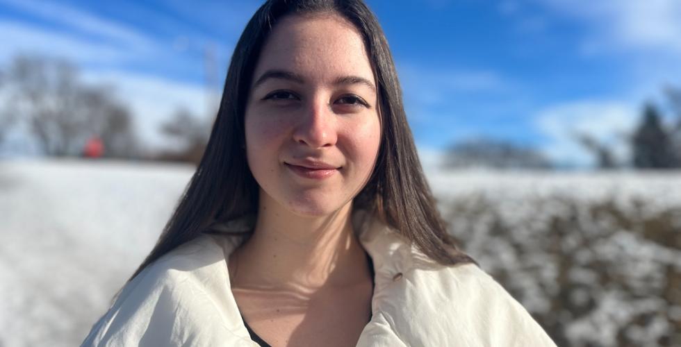 Alona i hvit jakke. Bakgrunn av sn&oslash; og sol