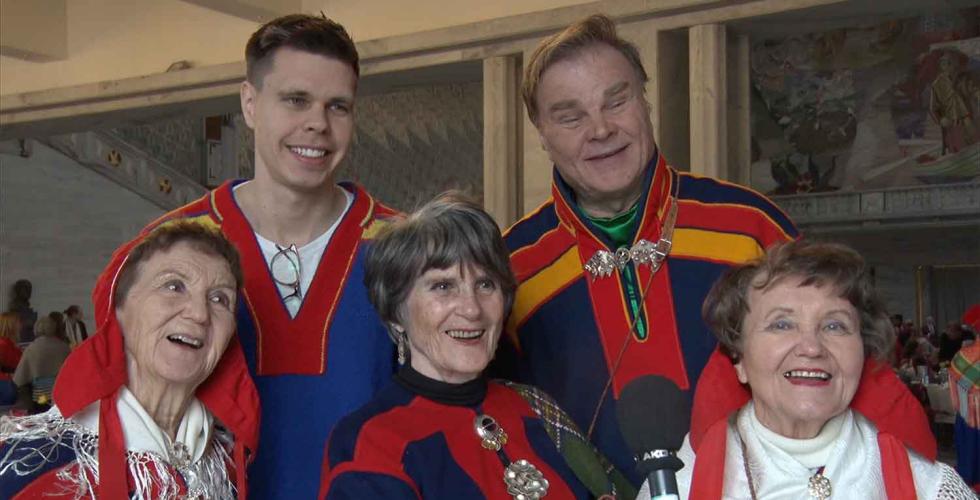 Fem samer som st&aring;r og smiler 