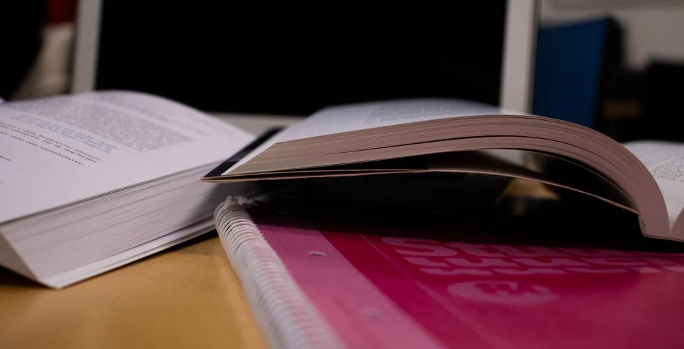 B&oslash;ker ligger str&oslash;dd utover en pult. 