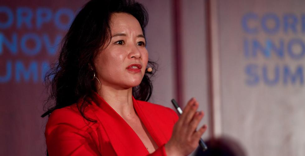 Cheng Lei st&aring;r og holder et foredrag p&aring; en konferanse