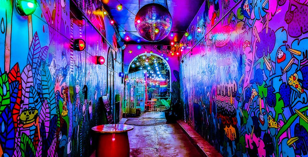 Inngang til et hus. Fargerike tegninger p&aring; veggene.