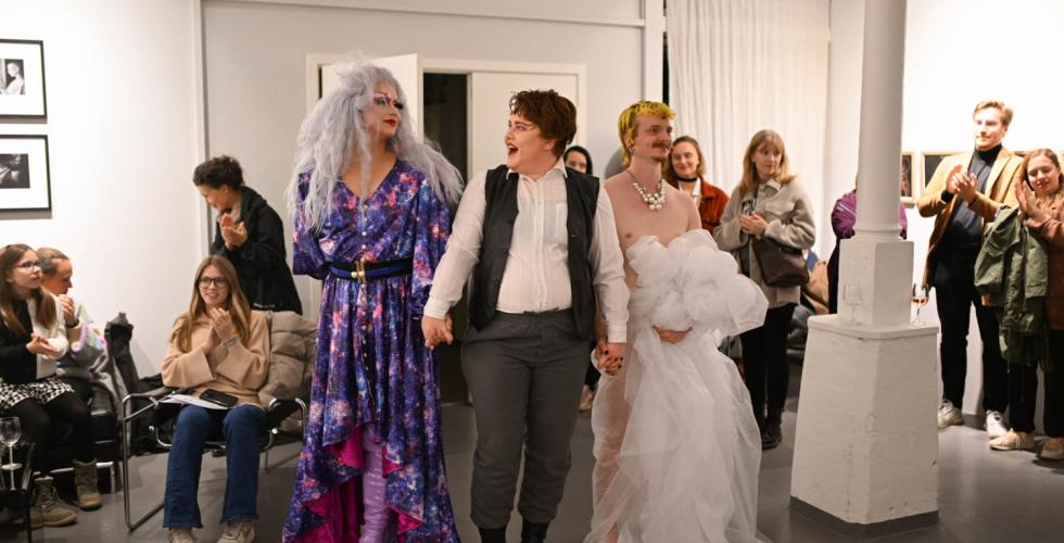 Tre personer f&aring;r applaus fra et publikum