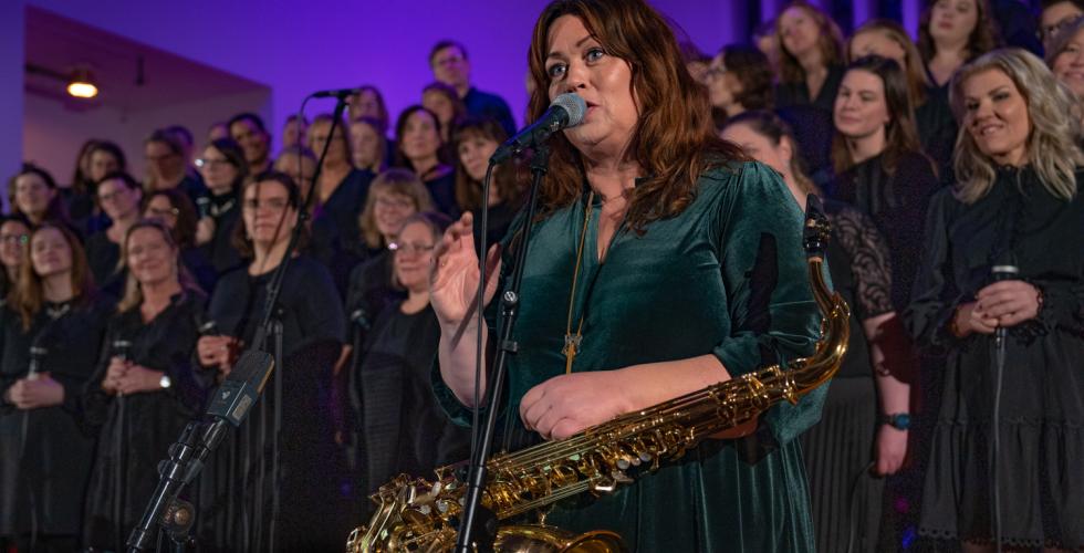 Saxofonist Fr&oslash;ydis Grorud st&aring;r foran koret Gospel explosion