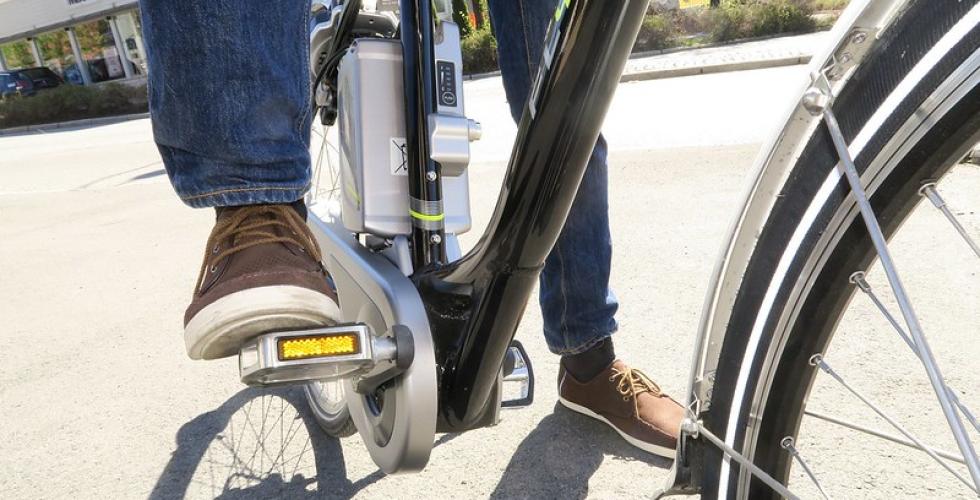 N&aelig;rbilde av en person som tr&aring;r p&aring; en elsykkel.