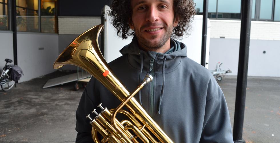 Ung mann som holder trompet p&aring; loppemarked