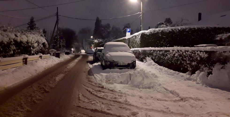 Biler parkert, det er kveld og sn&oslash;.