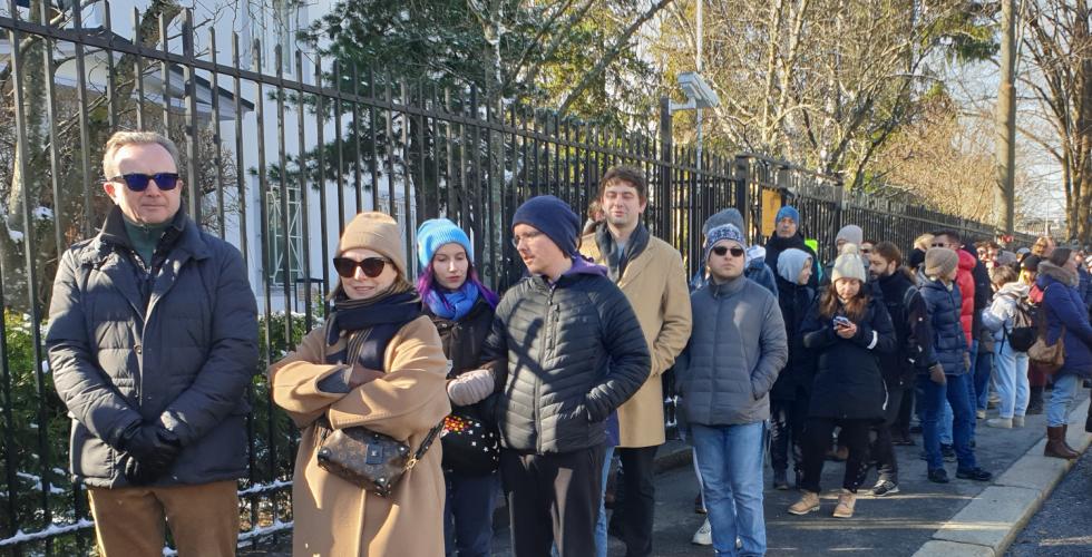 Mange mennesker st&aring;r og venter utenfor inngangen til den russiske ambassaden