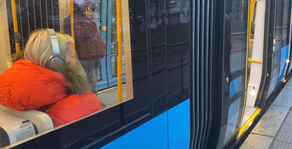 person som sitter p&aring; trikken med headset