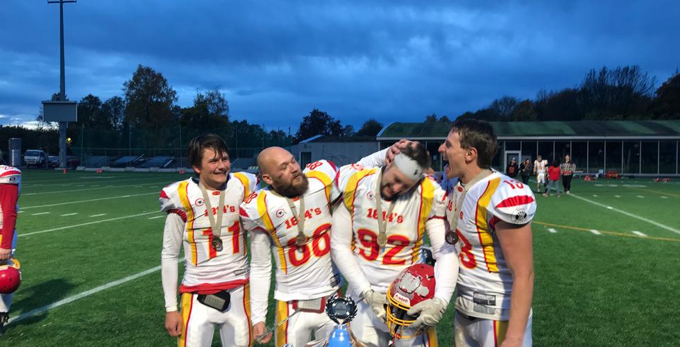 Fotball gutter st&aring;r p&aring; banen og er glade.