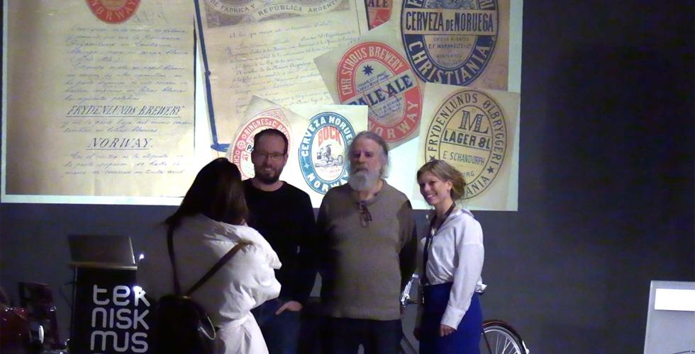 Tre foredragsholdere blir tatt bilde av p&aring; scenen