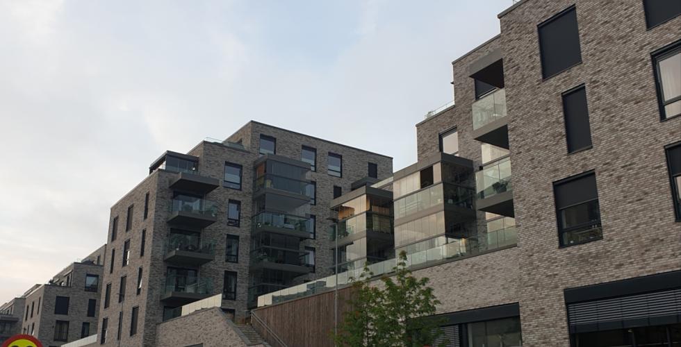 H&oslash;ye, gr&aring; og firkantede boligblokker av stein med gr&aring;tt v&aelig;r.