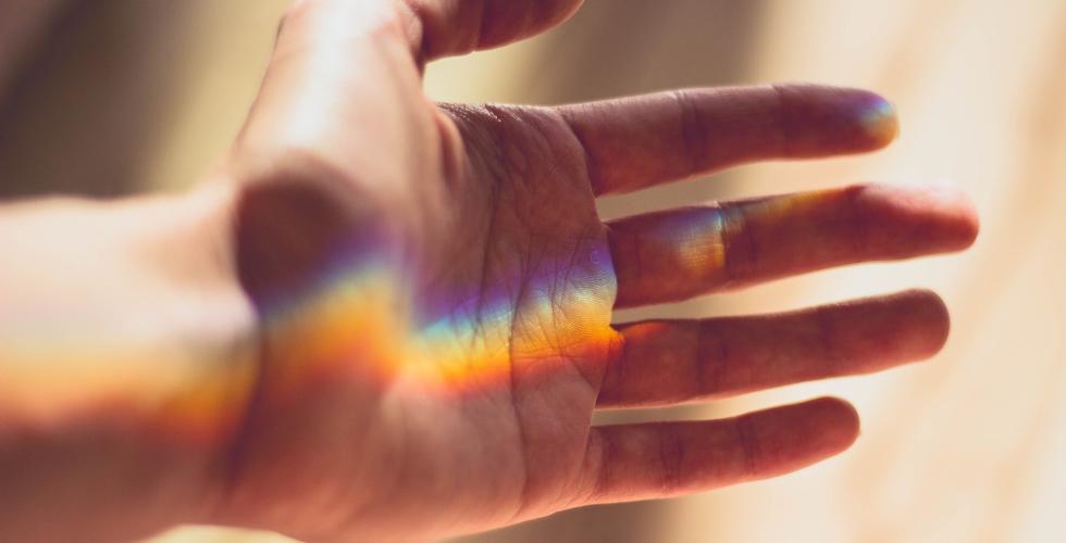 Bilde av en regnbue over en h&aring;nd