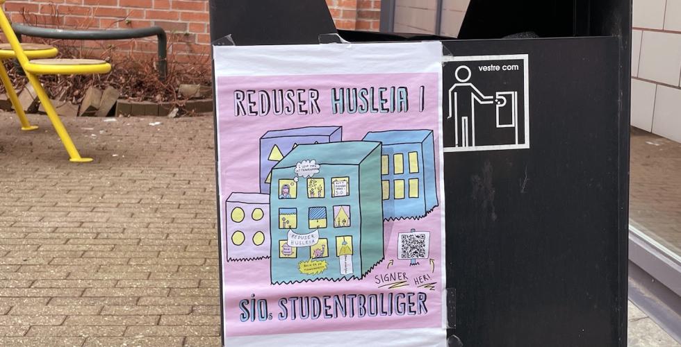 En rosa plakat p&aring; en s&oslash;ppelkasse, som er hengt opp av gruppen Reduser husleia.