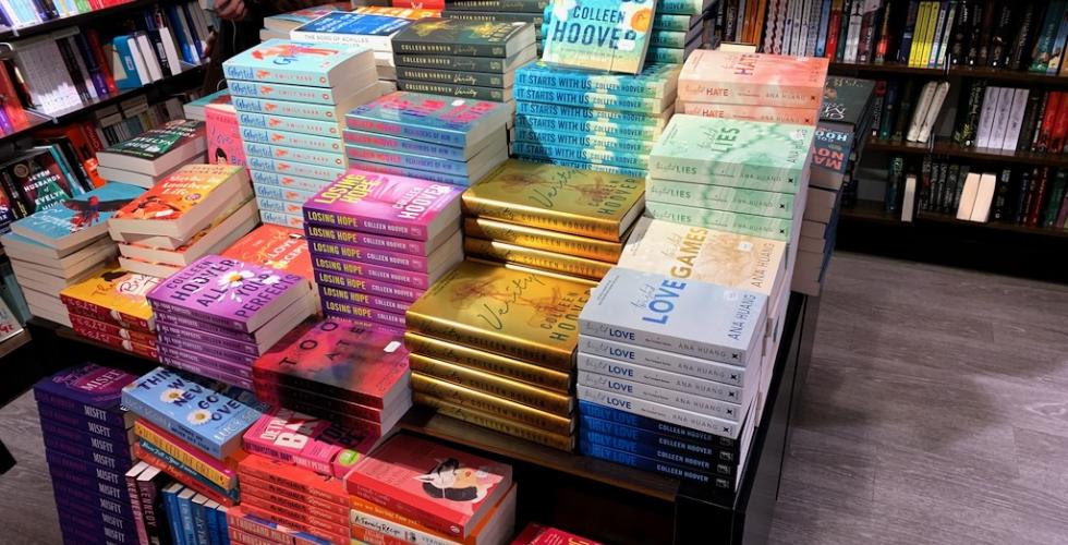 Et stort utvalg med b&oslash;ker som ligger p&aring; et utstillingsbord.